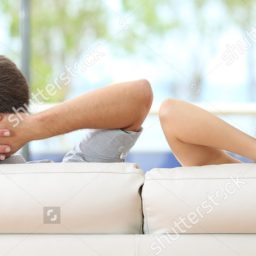 cropped-stock-photo-rear-view-of-a-couple-relaxing-on-a-sofa-at-home-and-looking-outside-a-green-background-through-the-417086011.jpg